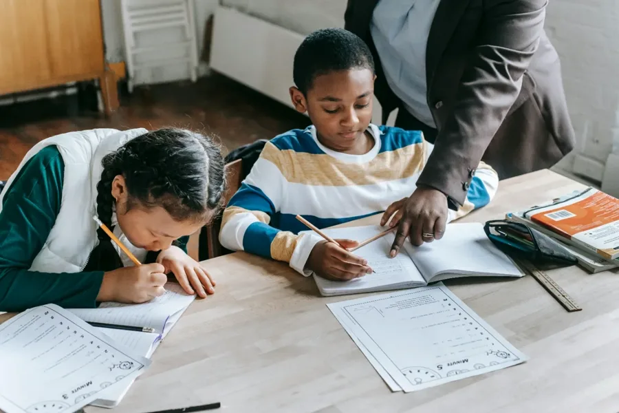 A Kaizen tutor helping two students work through their homework