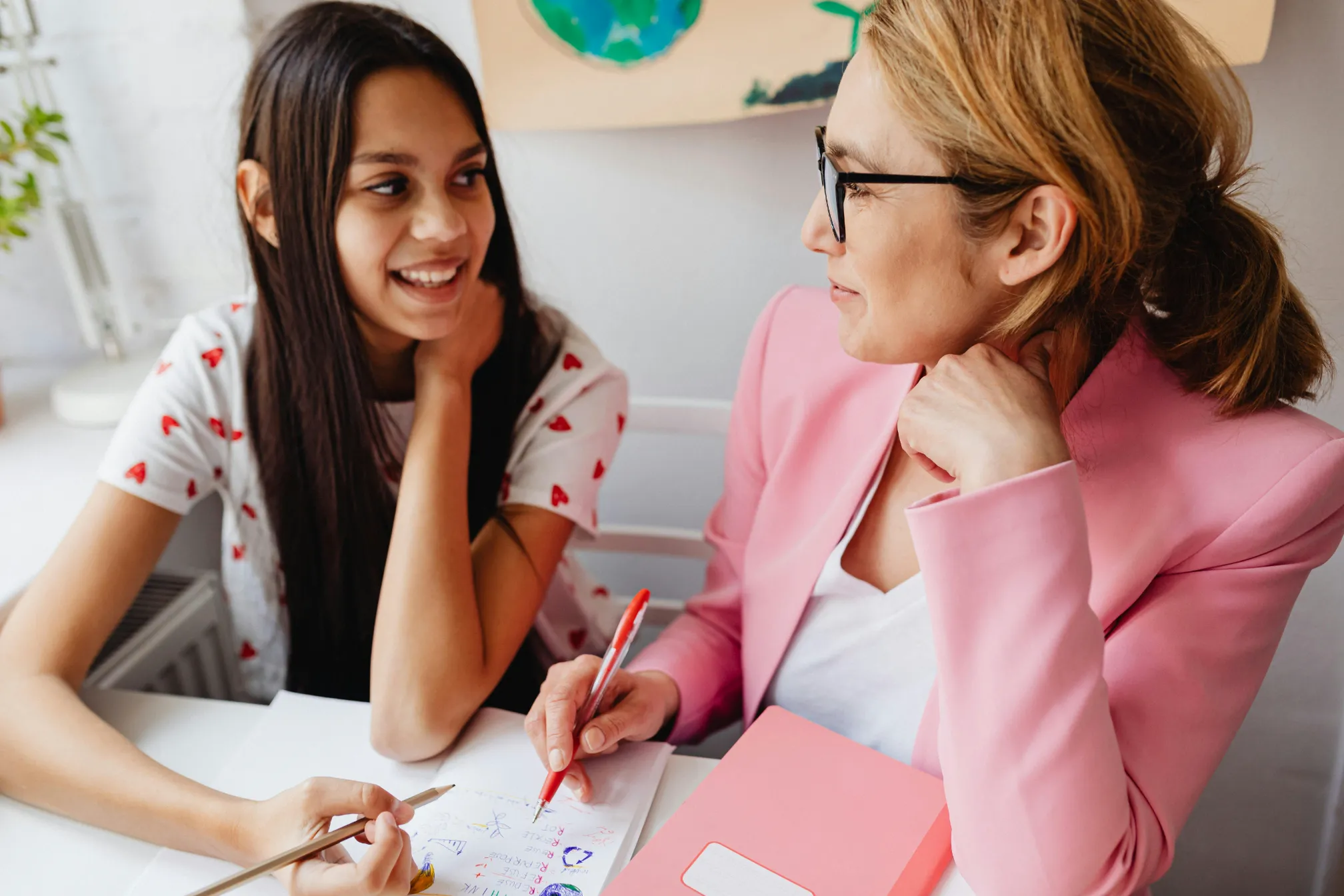 A tutor and a smiling student working through a written exercise together
